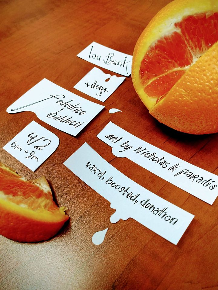 set info written out on small piece of paper on desk next to an orange. masked and vaxxed